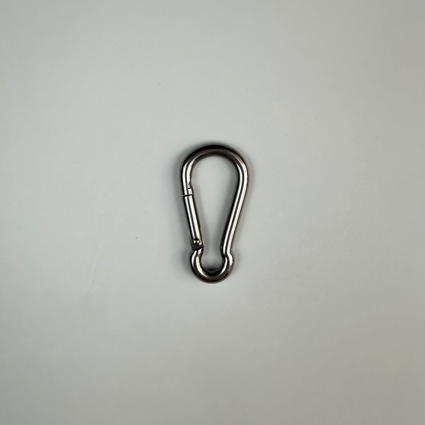 A stainless steel 6cm carabiner on grey background 