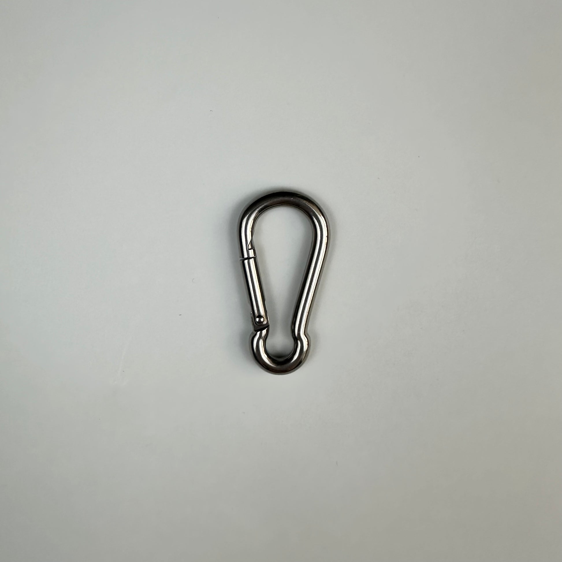 A stainless steel 6cm carabiner on grey background 