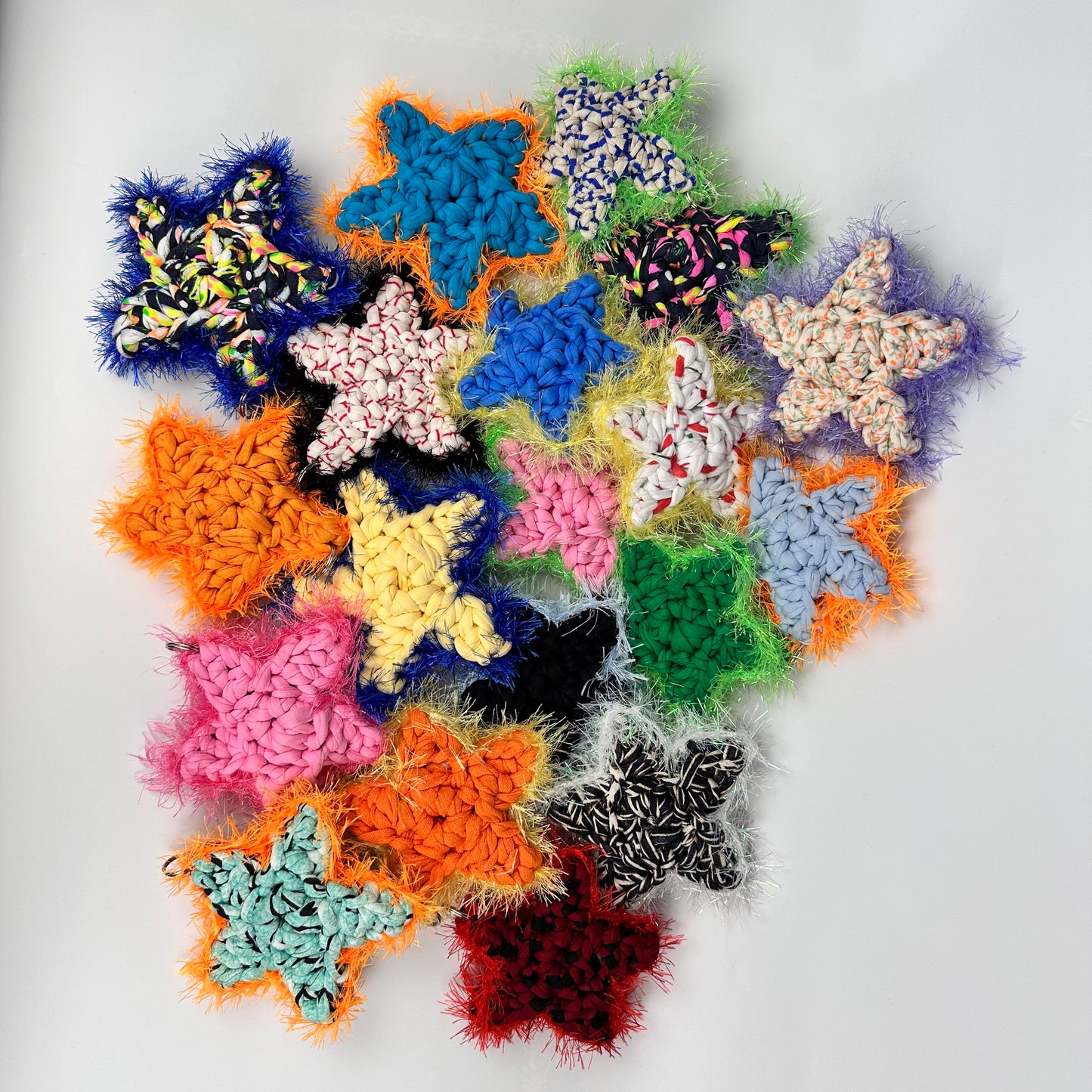 Colourful star-shaped bag charms on a white background